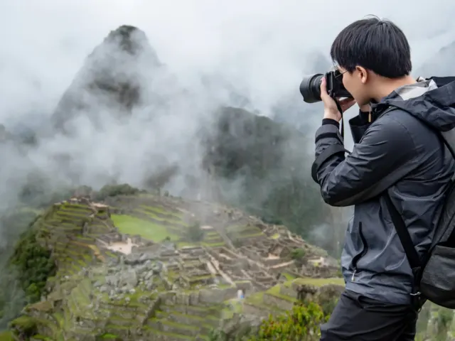 Turista fotografiando Machu Picchu